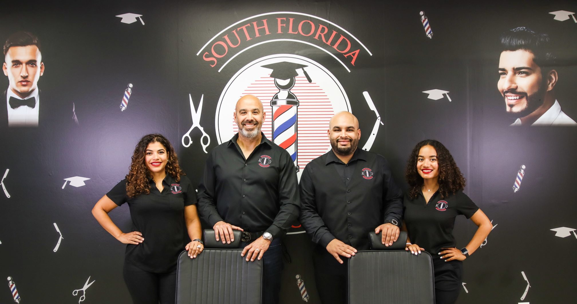 Group shot of Jessica, Albert, Joel, and Rachel standing in front of the South Florida Barber Schools logo