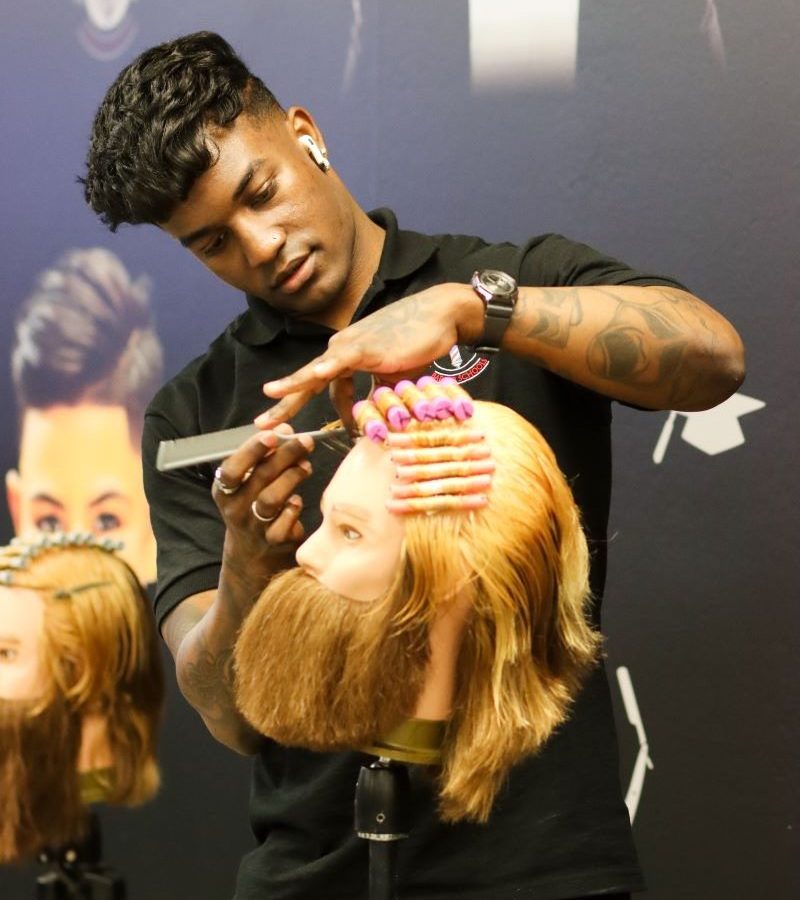 Student barber practicing on a mannequin