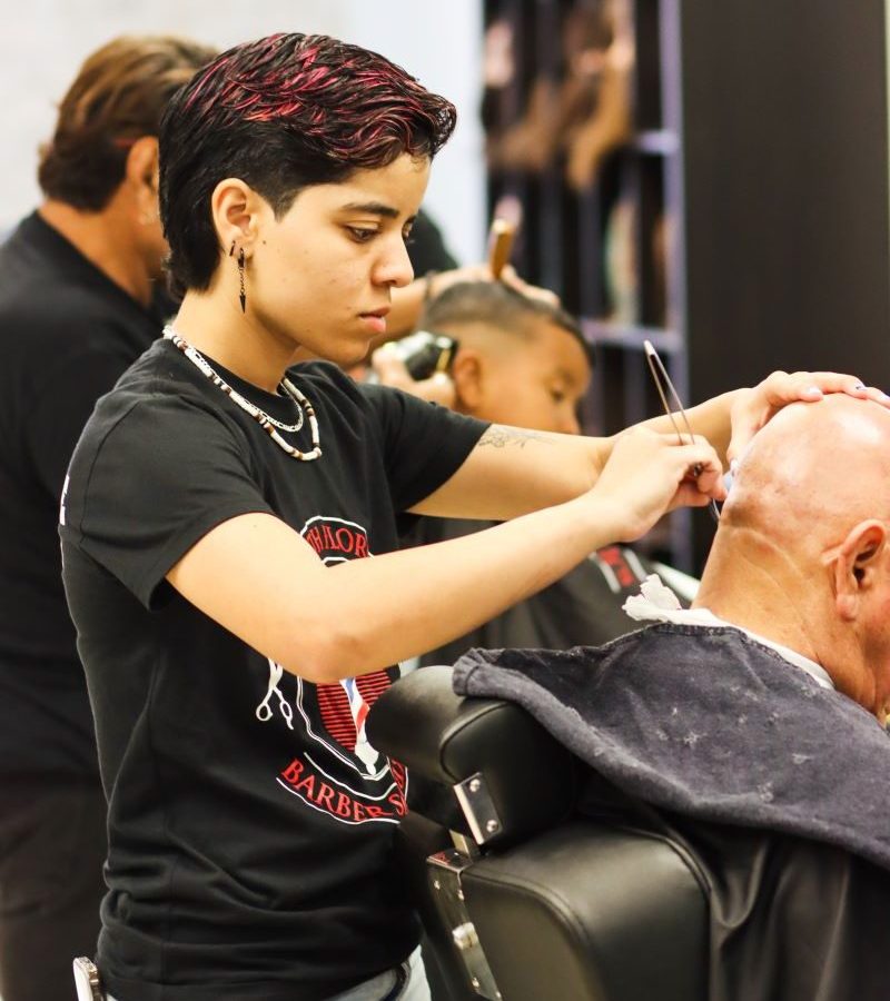 Student barber shaving a man's head